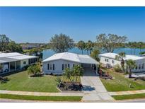 Waterfront property with well-manicured lawn, lush landscaping, and stunning lake views from this cozy home at 8409 Imperial Cir, Palmetto, FL 34221