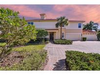 Beautiful home featuring a well-manicured lawn, a red brick driveway, and lush landscaping at 9441 Discovery Ter # 101A, Bradenton, FL 34212