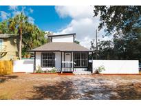 Charming bungalow home featuring a black and white design with a covered front porch and manicured landscaping at 1397 43Rd St, Sarasota, FL 34234