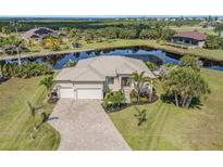 Stunning waterfront home with lush landscaping and a paver driveway at 16211 Cayman Ln, Punta Gorda, FL 33955