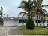 Charming single-story home with well-maintained landscaping, a garage, and inviting front porch at 1807 48Th W Ave, Bradenton, FL 34207