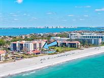 Panoramic aerial view of beachfront condo, showcasing the pristine sandy beach, ocean views, and resort-style pool at 1945 Gulf Of Mexico Dr # M2-110, Longboat Key, FL 34228