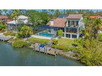 Waterfront home with a screened-in pool and private dock, surrounded by lush tropical landscaping at 3151 Bayou Sound, Longboat Key, FL 34228