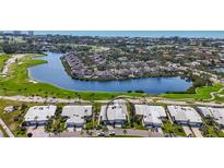 Stunning aerial view of the home in a community with a golf course, lakes, and beautiful landscaping at 3467 Byron Ln, Longboat Key, FL 34228