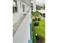 A balcony view with landscaped garden and walkway outside unit 302 with an American flag on the building at 4240 Ironwood Cir # 302A, Bradenton, FL 34209