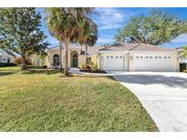 Charming single-story home with a three-car garage, lush green lawn, and mature landscaping at 4724 White Tail Ln, Sarasota, FL 34238