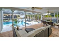 Screened patio boasts a pool, lounge chairs, outdoor seating, and waterfront views, perfect for entertaining at 552 Juan Anasco Drive, Longboat Key, FL 34228