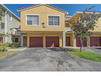 Inviting townhouse featuring a red tile roof, yellow stucco and private garage at 5601 Bentgrass Dr # 10-115, Sarasota, FL 34235