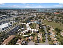 Aerial view of a condo community with mature trees and ocean views, close to parking and outdoor amenities at 618 Bird Bay S Dr # 118, Venice, FL 34285