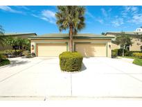 Inviting townhome with a two-car garage and a well-maintained front yard featuring a mature palm tree at 8536 54Th Avenue E Cir, Bradenton, FL 34211