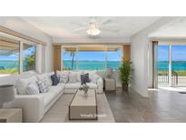 Bright living room features a large white sectional sofa with many large windows and a panoramic waterfront view at 10315 Cortez W Rd # 38Bv, Bradenton, FL 34210