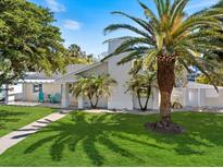 Charming home with a lush green lawn, mature trees and attractive landscaping, a welcoming sight for all at 106 N Blvd Of The Presidents, Sarasota, FL 34236