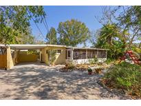 Charming yellow home featuring a screened-in porch and well-maintained landscaping at 109 Burney Rd, Osprey, FL 34229
