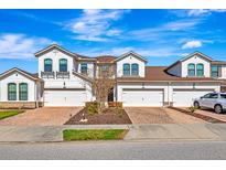 Charming townhome featuring a two-car garage, brick-paved driveway, and well-maintained landscaping at 11831 Brookside Dr, Bradenton, FL 34211