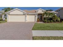 Lovely single-story home featuring a three-car garage, well-maintained lawn, and a beautiful tiled roof at 12022 Granite Woods Loop, Venice, FL 34292