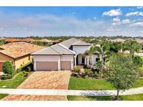 Beautiful single-Gathering home featuring a brick driveway, tropical landscaping, and a two-car garage in a desirable community at 12448 Golden Sage Dr, Sarasota, FL 34238