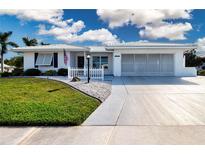 Charming single-story home featuring a white exterior, well-manicured lawn, and attached two-car garage at 1511 S Knollwood Dr, Bradenton, FL 34208
