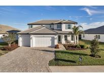 Stunning two-story home with a three-car garage and lush landscaping at 17703 Savory Mist Cir, Bradenton, FL 34211