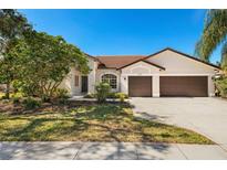 Charming single-story home with a well-manicured lawn, tile roof, and a spacious three-car garage at 240 Dove Trl, Bradenton, FL 34212