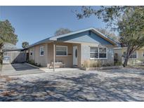 Charming single-story home featuring blue accents, a quaint front porch with bench, and a well-maintained yard at 511 74Th N Ave, St Petersburg, FL 33702