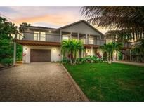 Beautifully landscaped home with a two-story design, balconies, and a well-maintained yard at 5708 Holmes Blvd, Holmes Beach, FL 34217