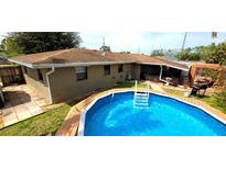 Backyard view of the sparkling blue pool, lush greenery, and relaxing patio area at 1011 68Th W Ave, Bradenton, FL 34207