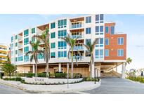 Modern condominium building with covered parking, lush landscaping, and convenient beach access at 1035 Seaside Dr # 603, Sarasota, FL 34242