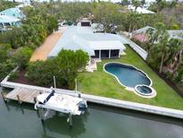 Beautiful waterfront home featuring a boat lift, backyard pool and patio on a meticulously landscaped lot at 110 Faubel St, Sarasota, FL 34242