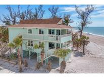 Coastal two-story home showcasing a beachside elevation, covered decks, and tropical landscaping at 2350 N Beach Rd # 1A, Englewood, FL 34223