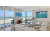 Bright living room featuring ocean views, a comfortable white sofa, and beach-themed decor at 2425 Gulf Of Mexico Dr # 3E, Longboat Key, FL 34228