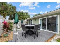Relaxing back patio with a dining area, sun umbrella, and sliding door entry at 4023 Center Pointe Pl # 3A, Sarasota, FL 34233