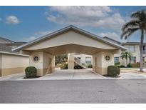 Inviting covered parking leading to well-maintained building entrance with stairs to upper units at 403 Auburn Lakes Cir # 403, Venice, FL 34292