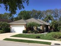 Charming single-story home featuring a well-manicured lawn and lush tropical landscaping in the front yard at 5548 Simonton St, Bradenton, FL 34203