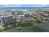 Expansive aerial view of beachfront condos with pristine beaches and ocean waters at 6063 E Peppertree Way # 111, Sarasota, FL 34242