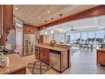 Well-lit kitchen with stainless steel appliances and an adjacent dining area with ocean views at 6140 Midnight Pass Rd # 103, Sarasota, FL 34242