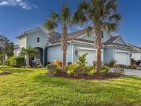 Beautiful light-blue two-story home with lush landscaping and a three-car garage at 6280 Cassia St, Bradenton, FL 34203