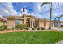 Charming single-story home featuring a well-manicured lawn, lush landscaping, and a welcoming double-door entry at 854 Dahoon Cir, Venice, FL 34293