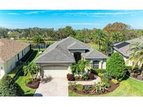 Beautiful front exterior features a brick driveway, lush landscaping, and a well-maintained lawn at 12263 Lavender Loop, Bradenton, FL 34212