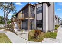 Two-story condo building with screened patios, light-colored facade, and wood stairway at 3758 59Th W Ave # 4099, Bradenton, FL 34210