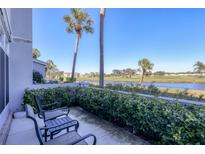 Balcony overlooking waterfront views and lush landscaping, creating a peaceful outdoor retreat at 404 Cerromar N Cir # 119, Venice, FL 34293