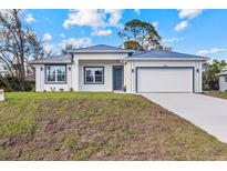 Charming single-story home featuring a modern design, well-manicured lawn, and a two-car garage at 4240 Adelaide Ave, North Port, FL 34288