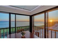 Dining room featuring panoramic water views, wood railing, and serene atmosphere at 4535 Bay Club Dr, Bradenton, FL 34210