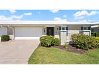 Charming home featuring an attached garage, mature landscaping, and a welcoming front entrance at 6902 8Th W Ave, Bradenton, FL 34209