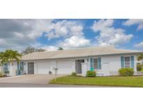 Charming single-story villa with tile roof, white exterior and vibrant blue shutters and accents at 7402 8Th W Ave, Bradenton, FL 34209