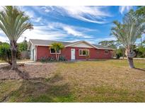 Charming single-story brick home featuring a well-maintained lawn and mature palm trees, creating a welcoming curb appeal at 801 Mcmahon Nw Ave, Port Charlotte, FL 33948