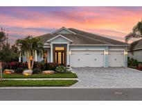 Charming single-Gathering home featuring a well-manicured lawn, beautiful landscaping, and a three-car garage at 813 Tailwind Pl, Sarasota, FL 34240