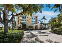 Stunning condo exterior featuring a lush landscape and brick-paved entrance, promising luxury living with a scenic backdrop at 2161 Gulf Of Mexico Dr # 3, Longboat Key, FL 34228