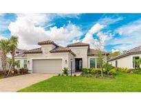 Charming one-story home with a neutral color scheme, attached garage, tile roof, manicured lawn, and verdant landscaping at 3639 Santa Caterina Blvd, Lakewood Ranch, FL 34211