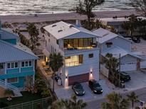 Modern three-story home boasting a white exterior, balconies, and beachfront access at 412 S Casey Key Rd, Nokomis, FL 34275