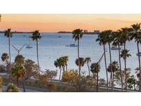 Stunning waterfront view with palm trees and boats on the horizon during a colorful sunrise at 435 S Gulfstream Ave # 601, Sarasota, FL 34236